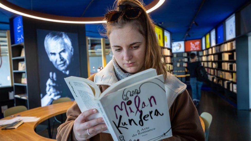 A visitor to the Milan Kundera library in Brno, Czech Republic reads a book by the Czech novelist on April 6, 2023. - Around 3,000 author copies of Milan Kundera's books, originally kept in his Paris flat, are now available at a new library in his native Czech city of Brno. The library opened on April 1, Kundera's 94th birthday, decades after the writer known for "The Unbearable Lightness of Being" left communist Czechoslovakia for France in 1975