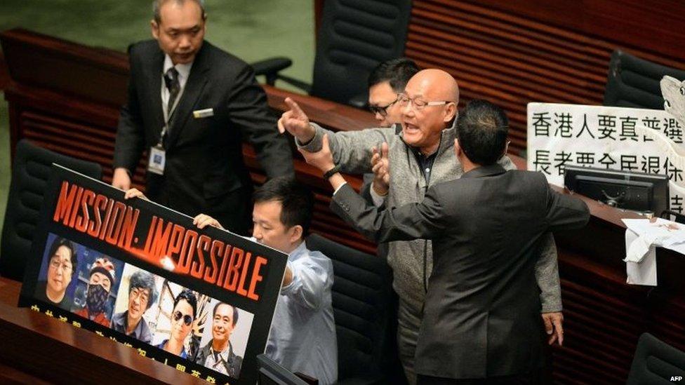 Politician Albert Chan is removed from Hong Kong's Legislative Council Chambers for protesting over the missing bookseller during a policy address by the chief executive, Leung Chun-ying