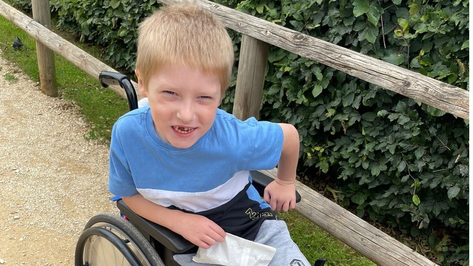 a boy in a wheelchair smiles