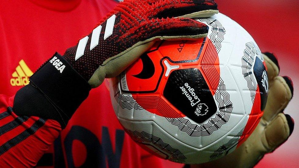 General view of a match ball held by Manchester United's David de Gea