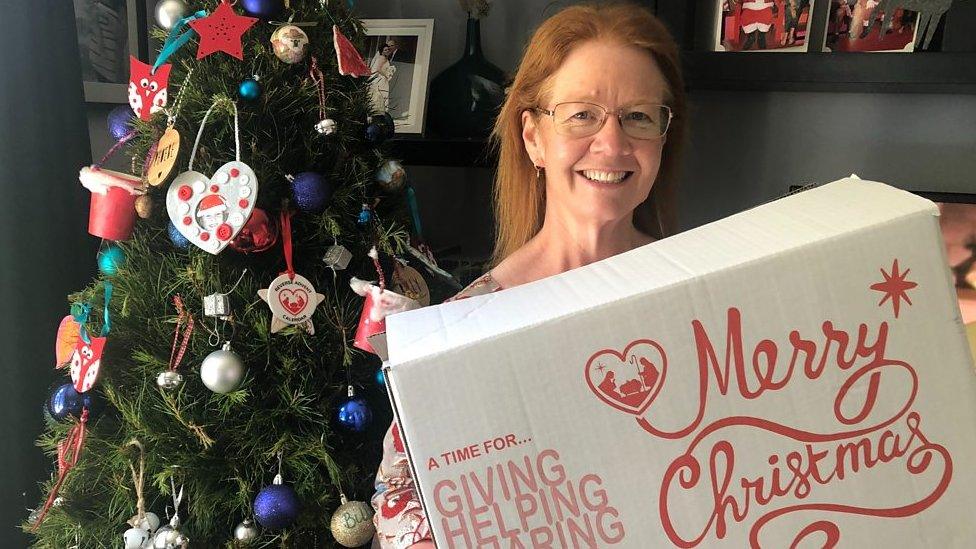 Woman holding reverse advent calendar box