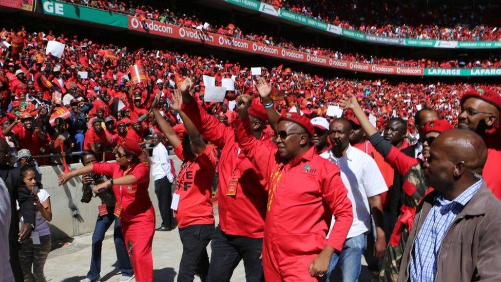 Julius Malema, foreground, second from right, greets supporters on his arrival at the launch of their municipal election manifesto in Soweto