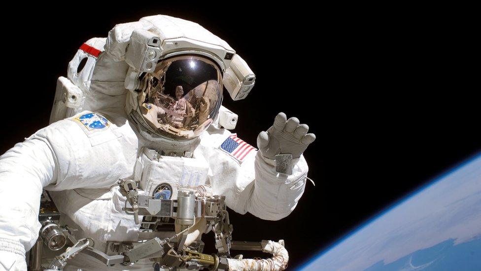 American astronaut Joseph Tanner waves to camera as part of 2006 ISS mission