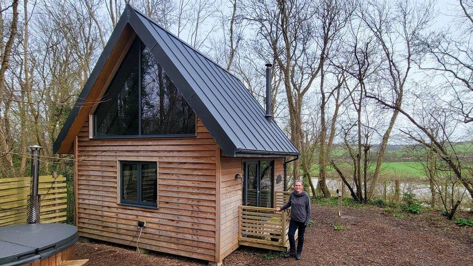 Mandy Foss standing in front of a cabin