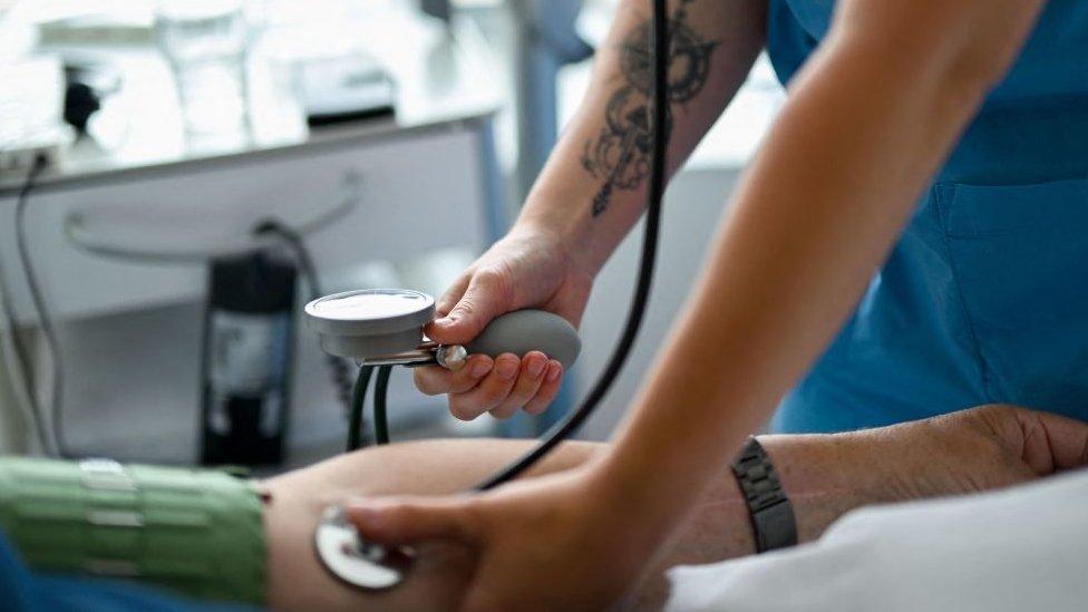 Nursing assistant 29-year Daria from Ukraine measures the blood pressure of a patient at the St. Johannes hospital in Dortmund, western Germany, on May 10, 2023