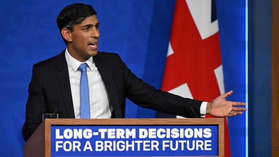 Prime Minister Rishi Sunak speaks from a podium in a briefing room inside Downing Street