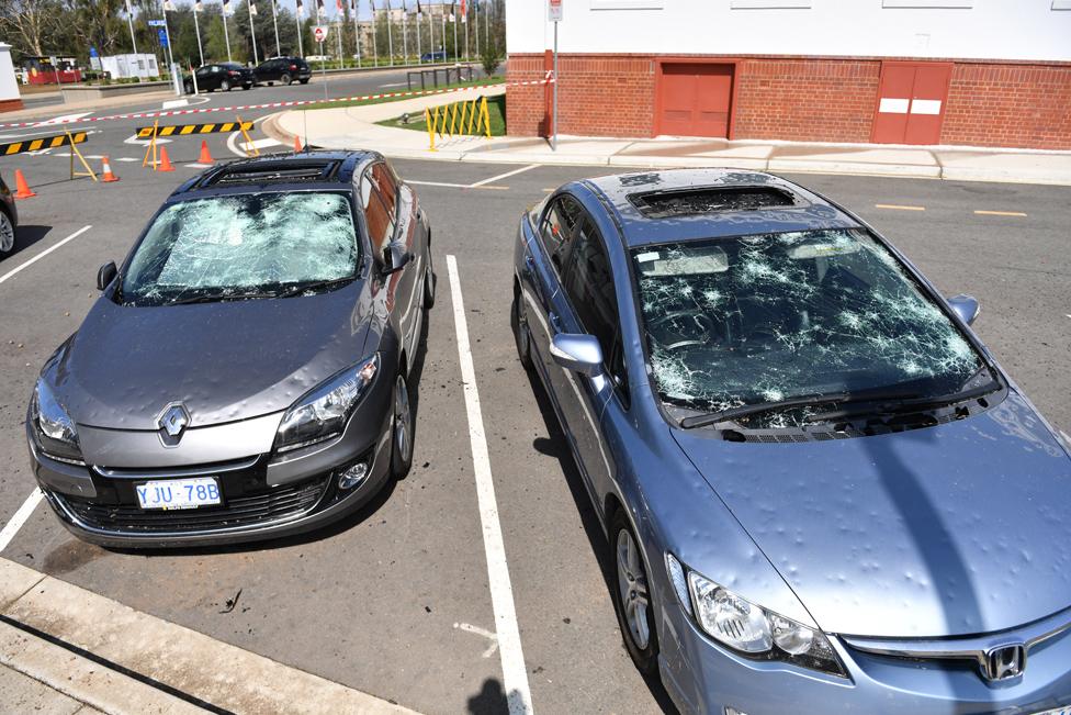 Damaged cars are seen parked outside Old Parliament House after a hail storm hit Canberra