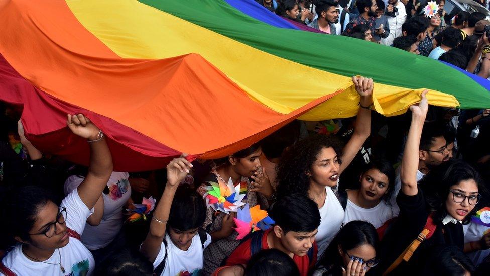 People holding an LGBT rainbow flag at Mumbai's first ever pride march