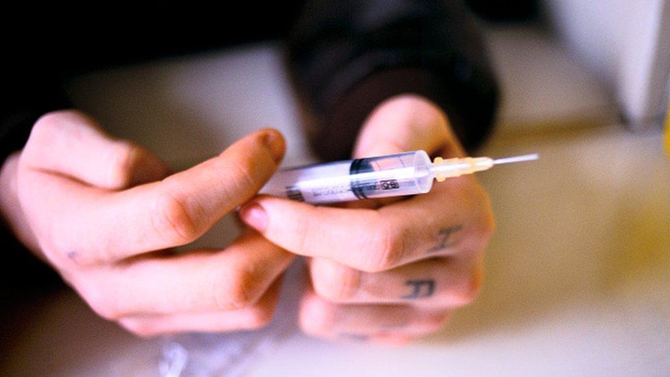 A man holding a syringe