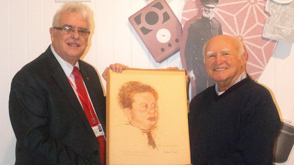 Dr Wyn Gittins handing the Dylan Thomas drawing over to councillor Robert Francis-Davies