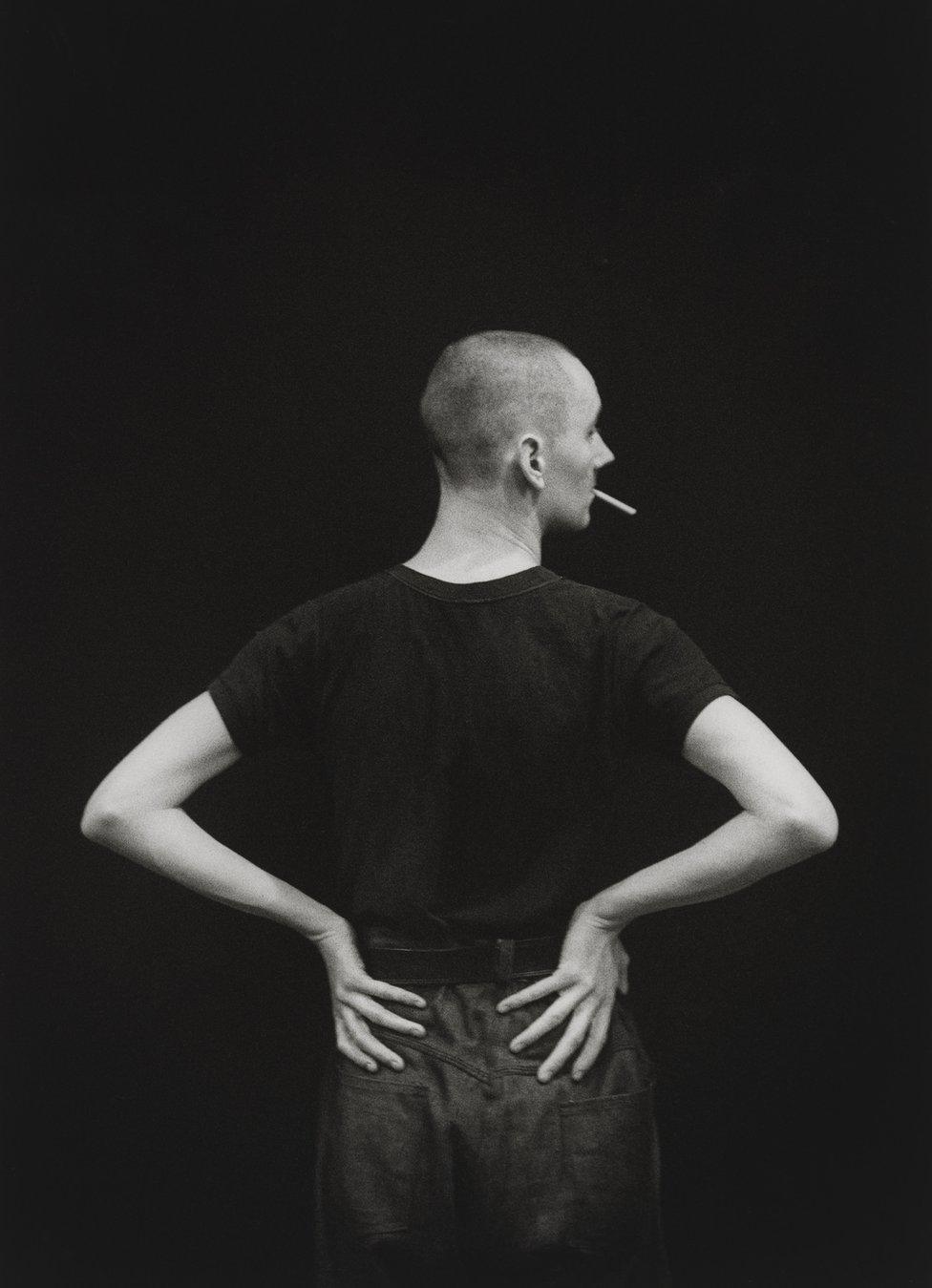 Cerith Wyn Evans stands with a cigarette in his mouth, circa 1984