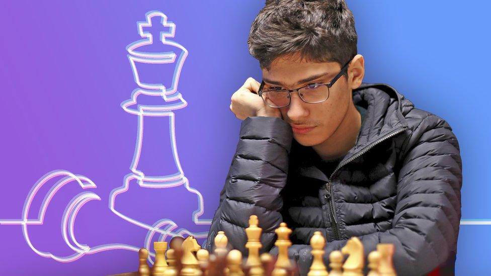 Alireza Firouzia studying a chessboard