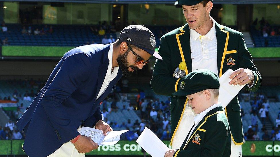 Virat Kohli (l) leans down to speak to Archie Schiller