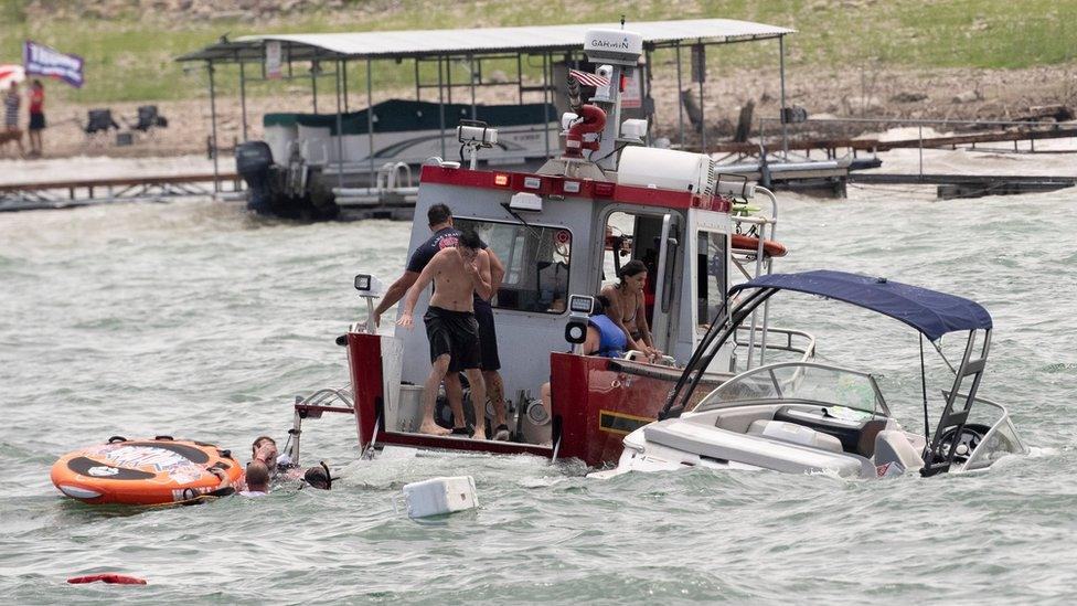 Boats partially submerged from the large wakes of a flotilla of supporters of US President Donald Trump