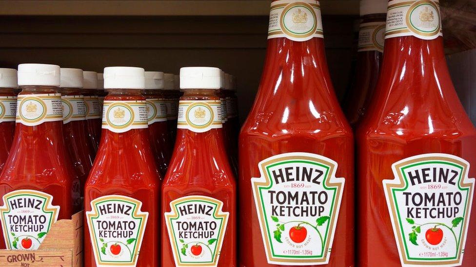 Bottles of Heinz Tomato Ketchup on a shop shelf.