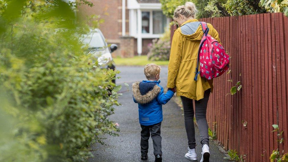 A parent and child walk to school