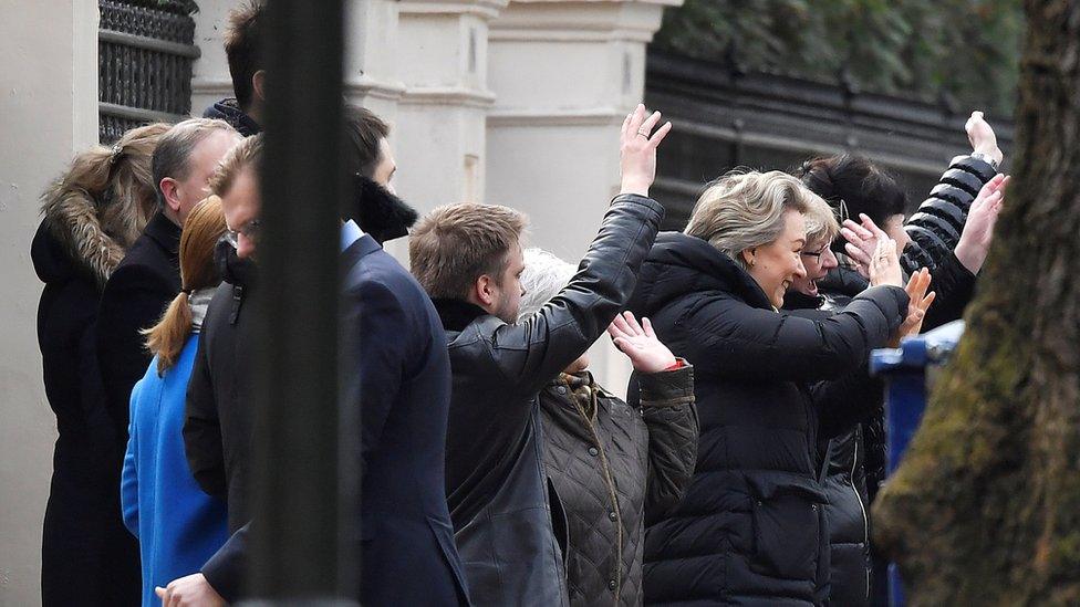 Embassy staff wave as colleagues and children board buses outside Russia"s Embassy in London,