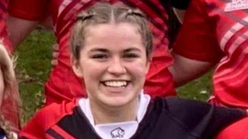 Maddy Lawrence smiling as she lines up for a rugby team photo shot