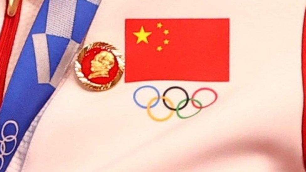 A Chinese cyclist wears a Mao badge during a medal ceremony at the Olympics