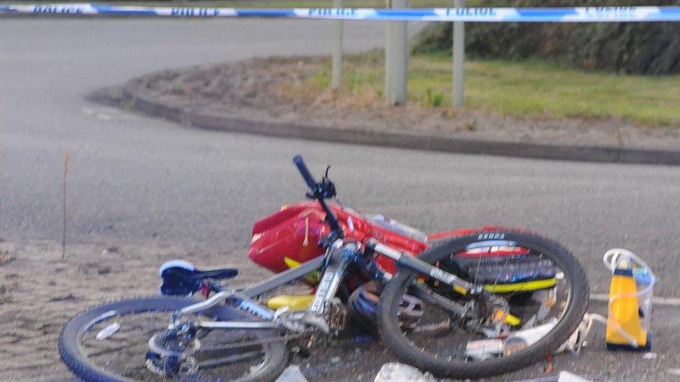 Wreckage of Jeremy's bike lying on its side on the road