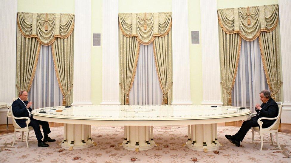 Vladimir Putin and Antonio Guterres sit several metres apart at opposite ends of a very large ornate table