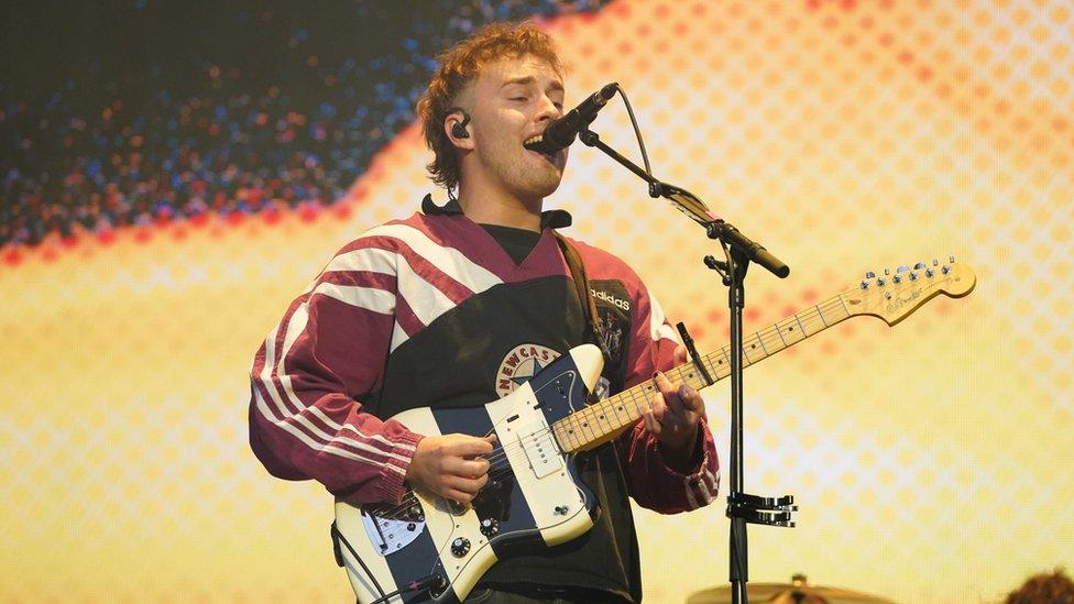 Sam Fender playing a set, holding a guitar