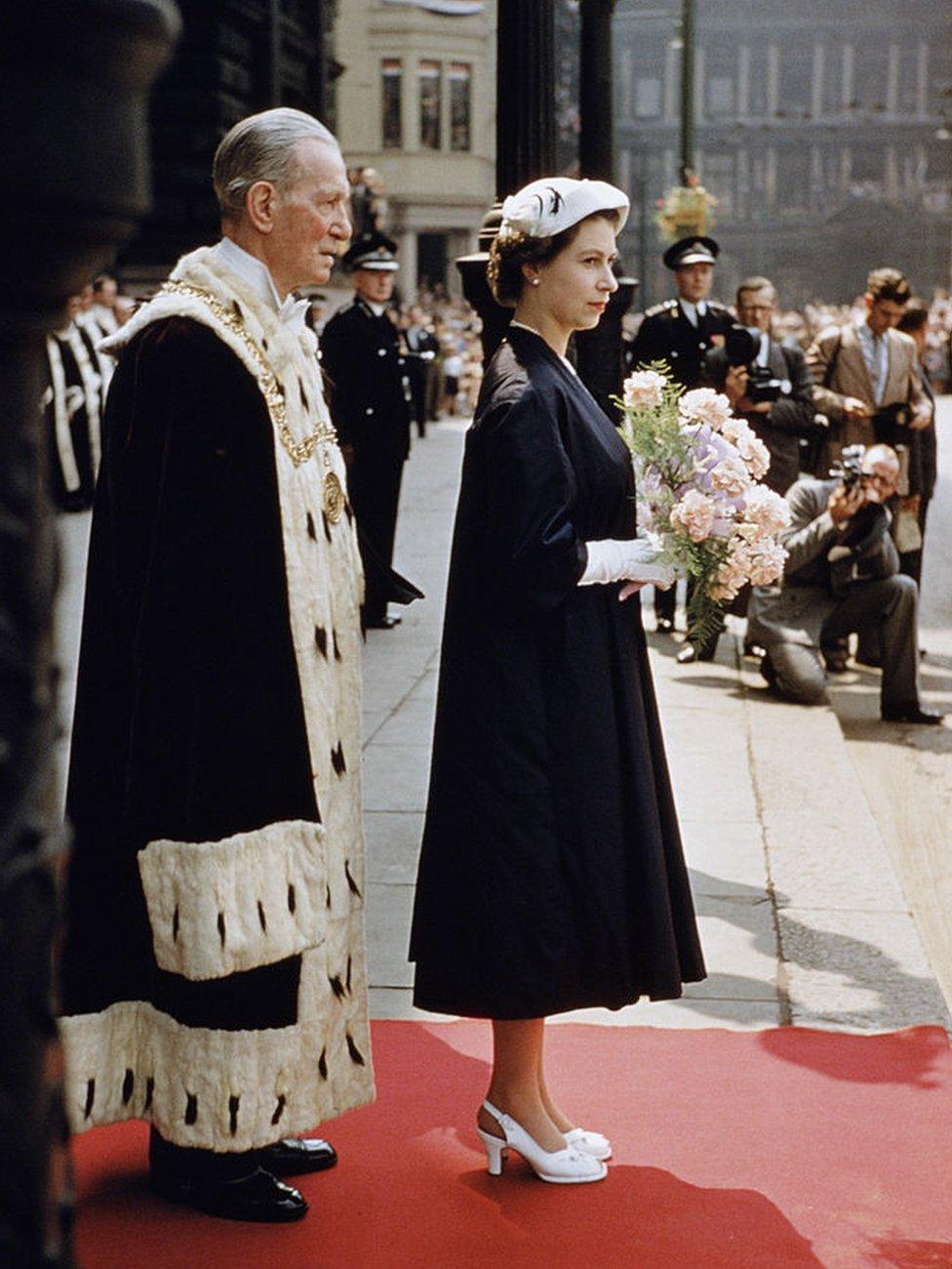 Queen Elizabeth outside the City Chambers in Glasgow during a Coronation Tour of Scotland, 1953. Standing behind her is the Lord Provost of Glasgow, Thomas Kerr.