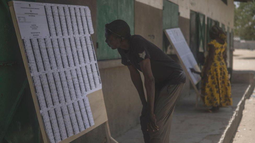 A man searches for his name on the voter's roll at a polling station in N'Djamena on April 11, 2021