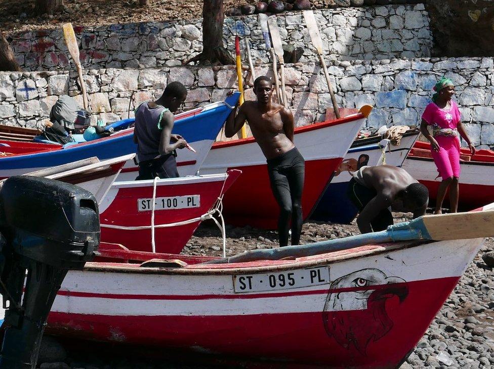 Young Cape Verdians standing by fishing boats