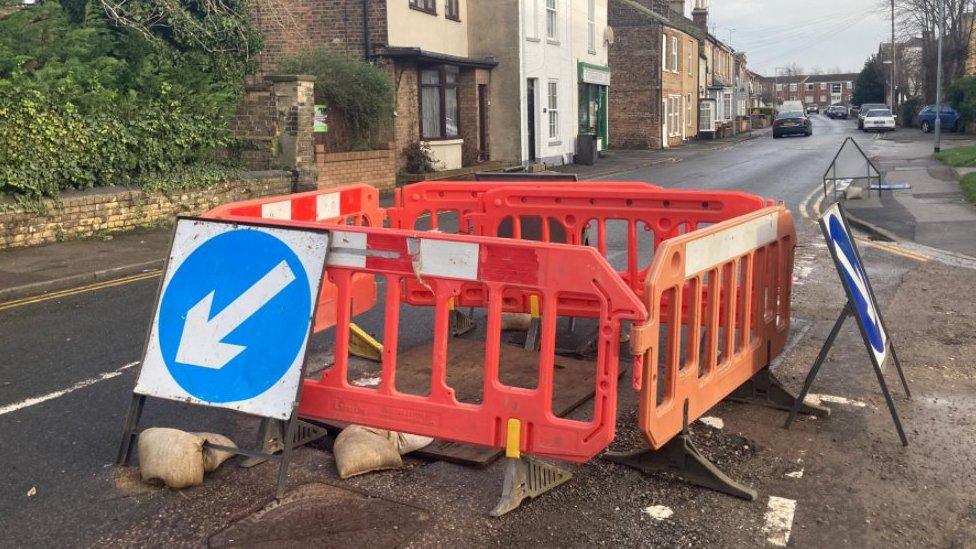 Cordoned-off hole in road