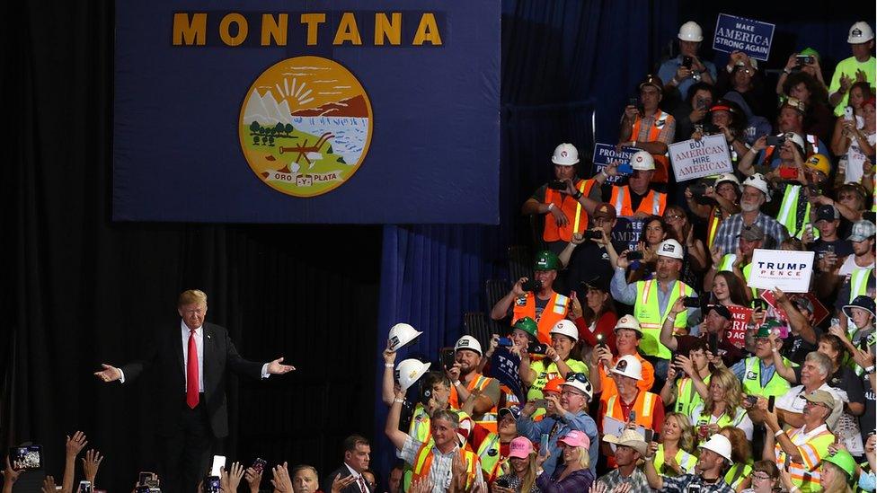 Trump greeting supporters under a banner with Montana written on it