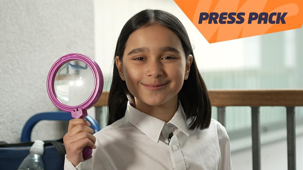 Girl holding magnifying glass