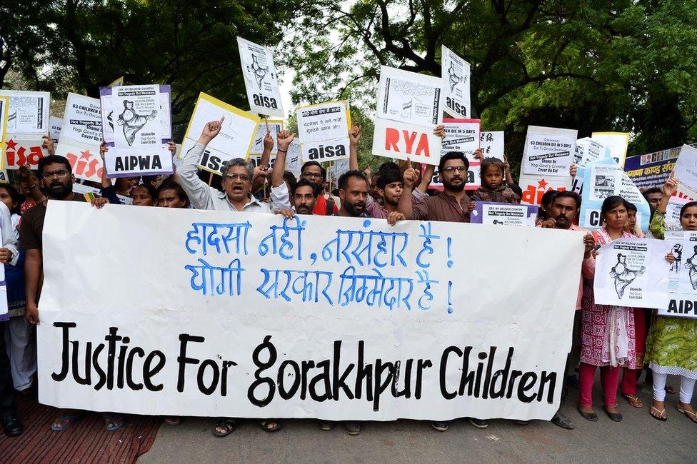 Protestors hold placards and shout slogans against the deaths of at least 64 children at the Baba Raghav Das Hospital in Gorakhpur.