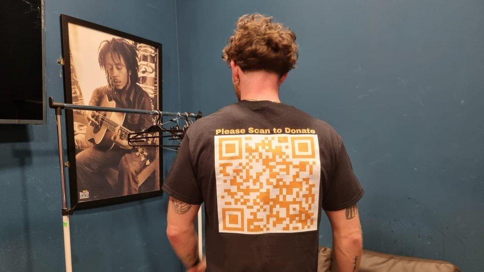 Tom Grennan wearing a shirt with a qr code