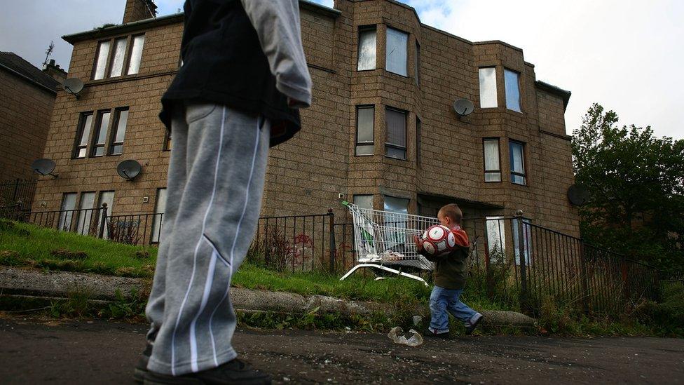 Children playing in front of a boarded up tenement in Glasgow