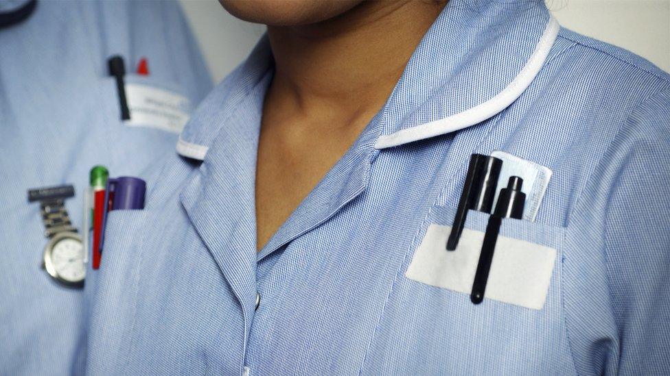 Close-up of two typically dressed NHS nurses