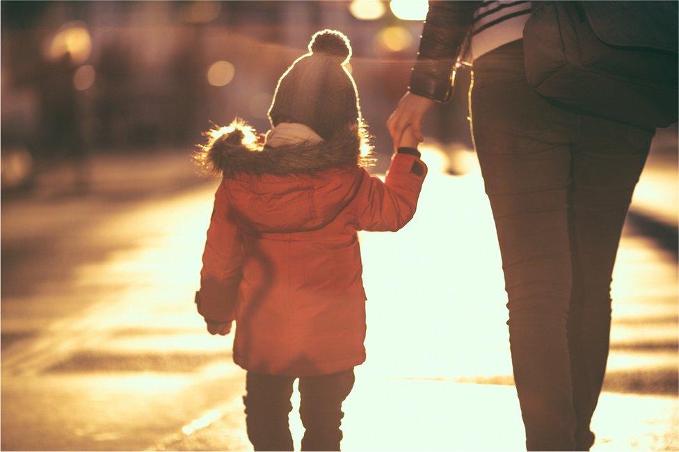 Boy holding mother's hand