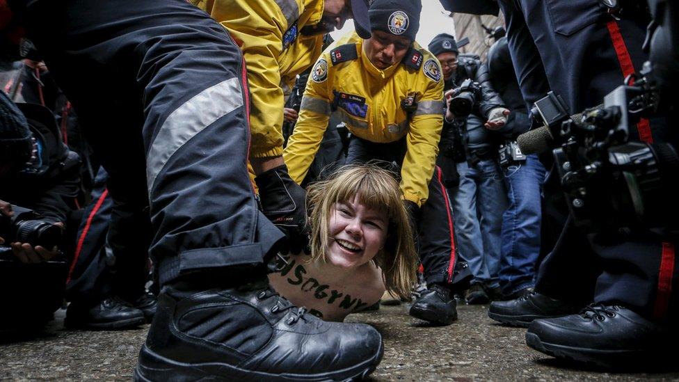 A shirtless protester is detained by police after an Ontario judge found former Canadian radio host Jian Ghomeshi not guilty on four sexual assault charges and one count of choking, in Toronto, March 24, 2016