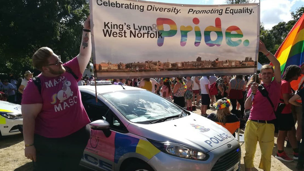 Josh Elms holding Pride banner