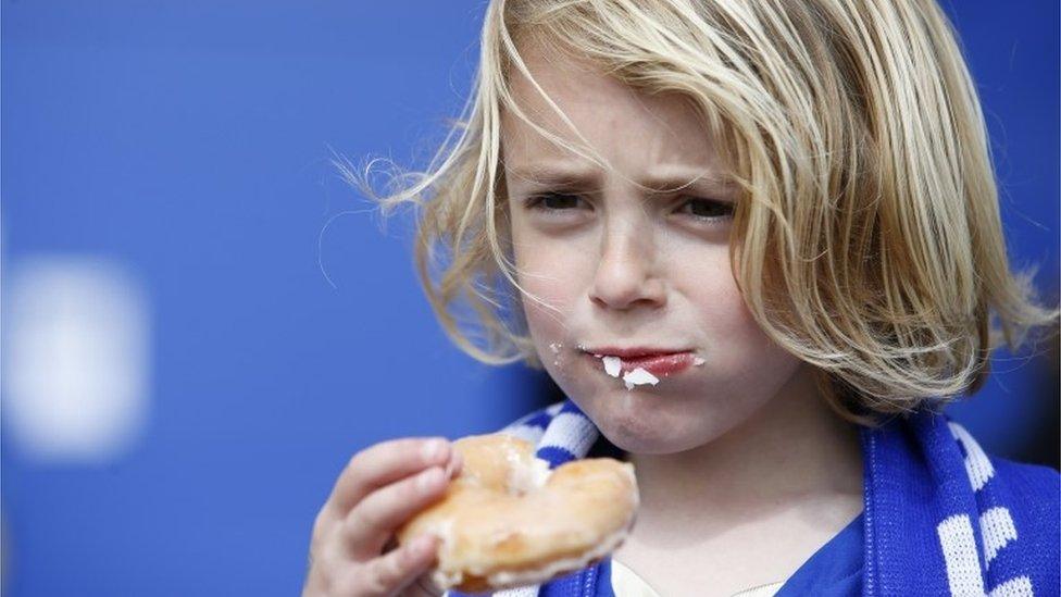 Fan eats his free Leicester City doughnut