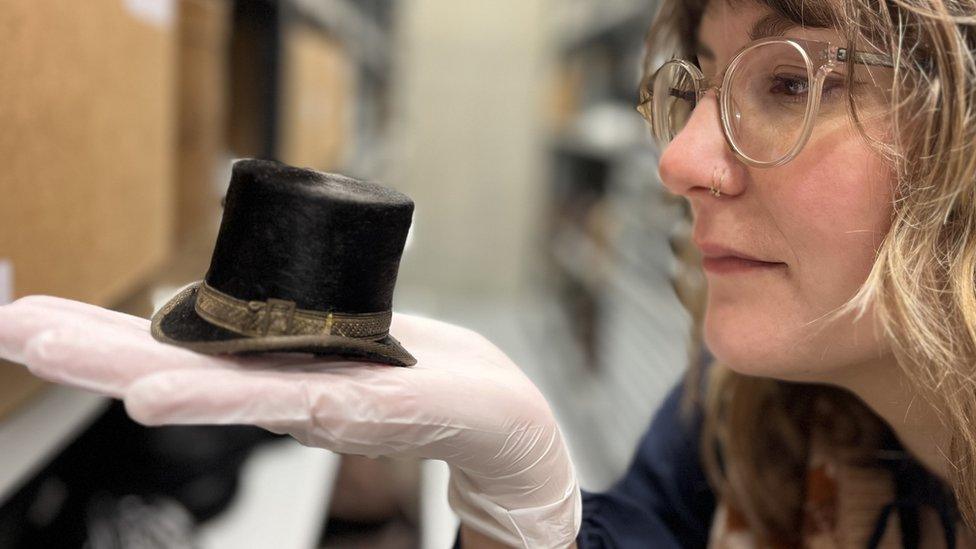 Curator with tiny top hat