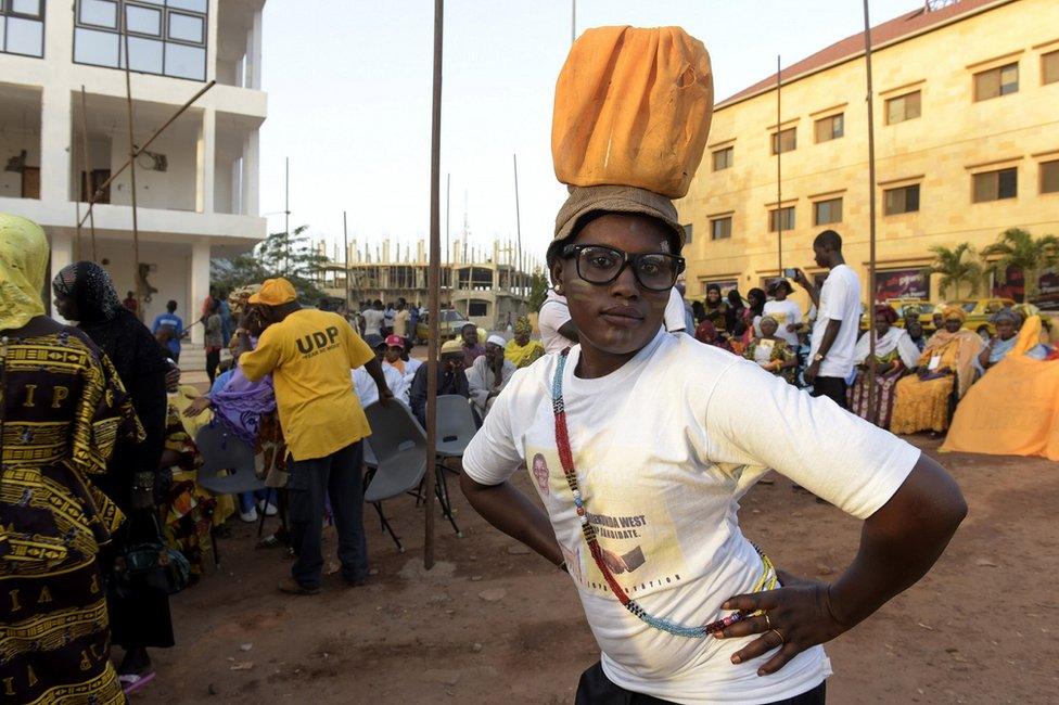 A supporter of a parliamentary candidate in The Gambia strikes a pose on Tuesday, two days before the first post-Jammeh polls