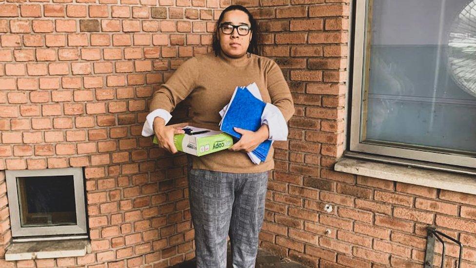 Lana holding books outside of school