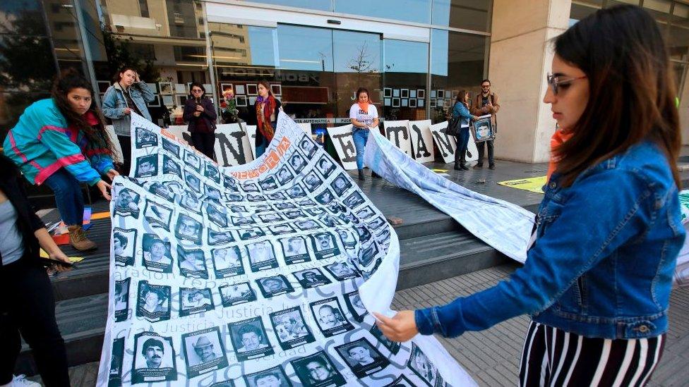 People demonstrate against the "false positives", executions of civilians at the hands of the military who presented them as combat casualties to swell results of the armed conflict, in front of the Special Jurisdiction for Peace in Bogota, on February 12, 2020.