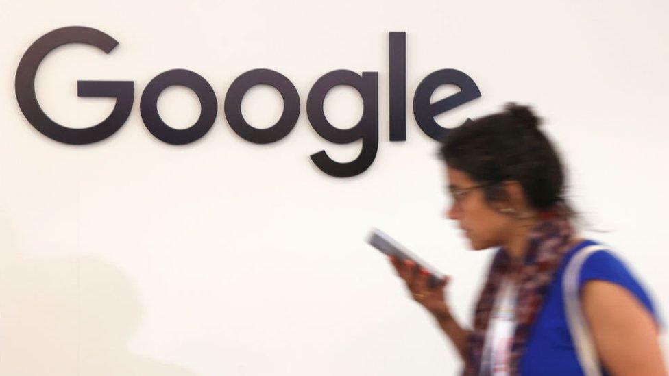 An attendee walks past a Google logo during the Viva Technology conference at Parc des Expositions Porte de Versailles on June 14, 2023 in Paris, France.