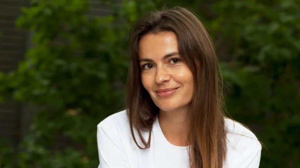 Image of Jess McDonald wearing a white t-shirt in front of a green background.