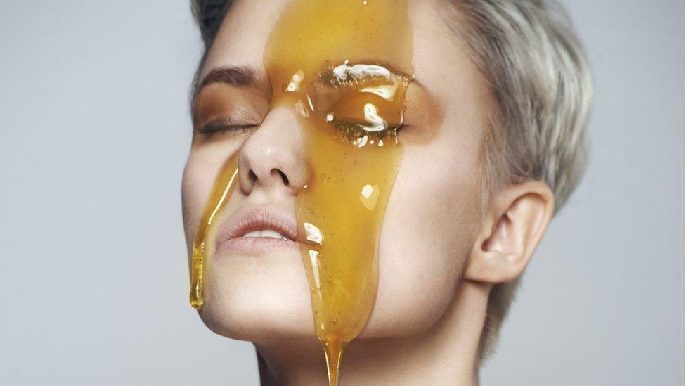 A woman with honey on her face