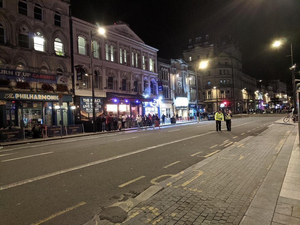 Police on duty and socially-distant queuing in place in St Mary Street on Friday night