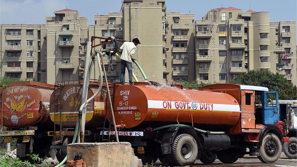 In this photograph taken on March 16, 2015, a sign that reads "Beware deep water ahead, dont go inside" sits near a fenced off dried up pond where water should be collected in the Dwarka sector of New Delhi.