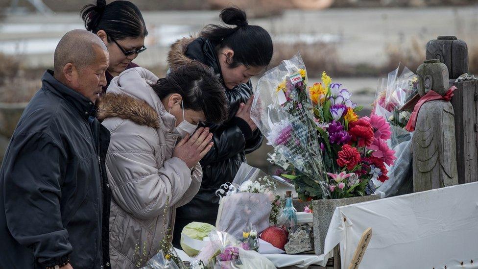 People visiting the makeshift shrine in Minamisanriku